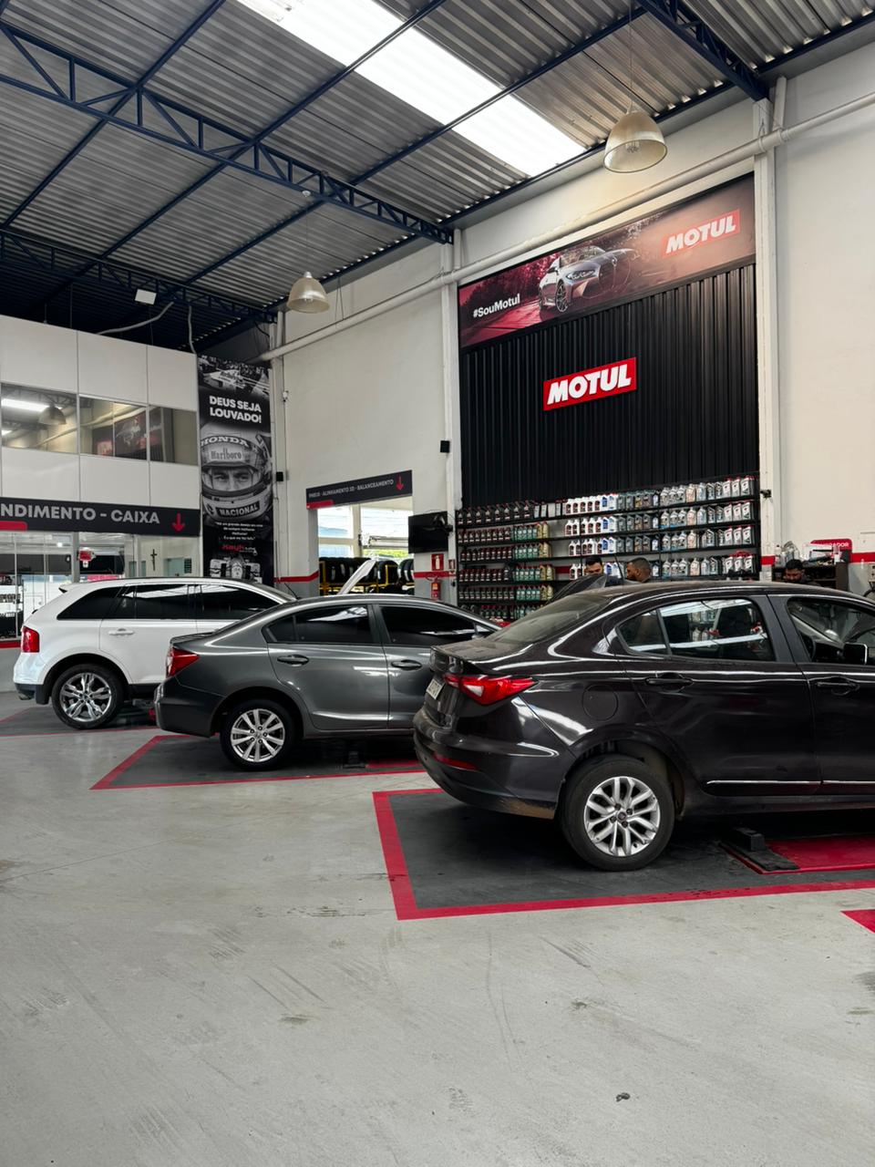 Interior da oficina Kayk Lube com veículos em atendimento